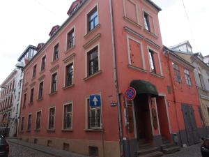 a red building on the side of a street at Amber Private Rooms in Riga