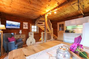 a kitchen and living room with a wooden ceiling at Ferienhof Pfefferbauer in Saalbach Hinterglemm