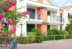 un edificio con fiori rosa di fronte di Sunny Apartment On The Sea a Cavallino-Treporti