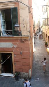 a little girl walking down a street next to a building at Torre Cepollini in Albenga