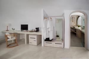 
a room with a desk, chair, and a dresser at Aperto Suites - Adults Only in Fira
