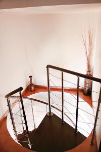 a spiral staircase with a metal railing in a room at Casa Rural Fuente Caraila in Júzcar