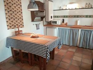 a kitchen with a table with a table cloth on it at Conjunto Rural Casa Victoria in Villaluenga del Rosario