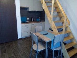 a kitchen with a table and chairs and a staircase at Apartamenty i pokoje "U Dawida" in Mrzeżyno