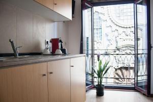 a kitchen with a sink and a large window at Nations Porto - Studios & Suites in Porto