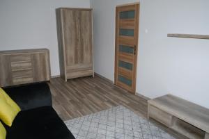 カトヴィツェにあるIndustrialny apartament Mariackaのリビングルーム(ソファ、木製家具付)