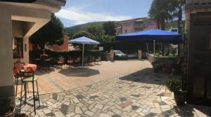 a patio with umbrellas and tables and chairs at Guesthouse Villa Manda in Lovran +15 photos
