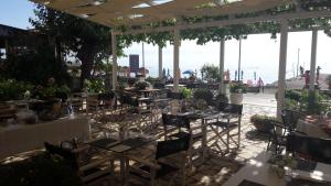 a restaurant with tables and chairs with a view of the ocean at Eros Beach Hotel in Benitses