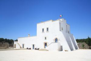 a white building with a staircase in front of it at Antica Masseria Torre Mozza in Torre Santa Susanna