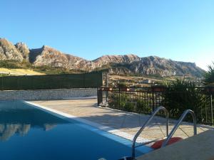 a swimming pool with a mountain in the background at Kairos B&B in San Giuseppe Jato