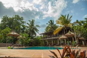 a resort with a swimming pool and a building at Villa Pinnawala & Restaurant in Pinnawala
