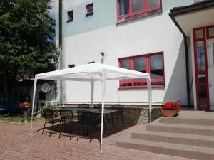 uma mesa com um guarda-chuva branco em frente a um edifício em Hotel O.K. 1 em Beroun