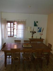 a dining room with a wooden table and chairs at Chalé em Ilhabela - Praia de Itaguassu in Ilhabela