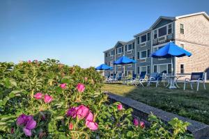 uma vista para um edifício com cadeiras, guarda-sóis e flores em Cutty Sark Motel em York Beach