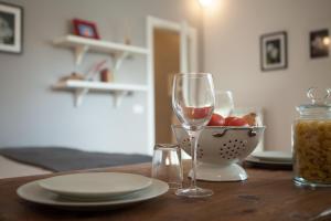 una mesa con una copa de vino y un bol de fruta en Central Pitti Studio Flat, en Florencia