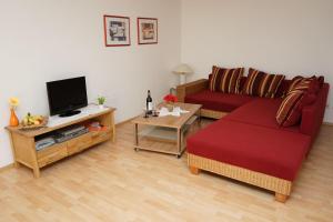 a living room with a red couch and a tv at Ferienwohnung-Jungbauernhof in Alpirsbach