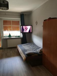 ブワディスワボボにあるApartament Masajkaのベッドルーム(ベッド1台、薄型テレビ付)