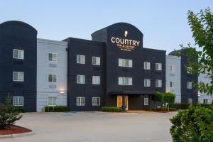 ein Gebäude mit einem Schild, das die Dienstleistungen von Landhotel liest in der Unterkunft Country Inn & Suites by Radisson, Shreveport-Airport, LA in Shreveport