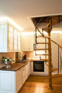 a kitchen with white cabinets and a spiral staircase at Apartamenty Euphoria in Gołdap