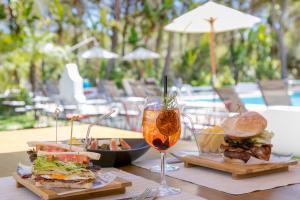 a table with two sandwiches and a glass of wine at Casbah Formentera Hotel & Restaurant in Playa Migjorn +34 photos