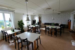 a dining room with tables and chairs and a couch at STF Sigtuna Vandrarhem in Sigtuna