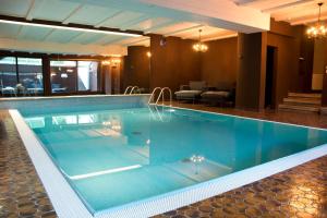 a swimming pool with blue water in a hotel at Residence Mayr in Castelrotto