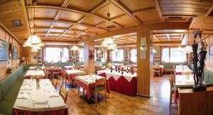 Un restaurante con mesas y sillas en una sala. en Hotel Principe, en Selva di Cadore 40 fotos más