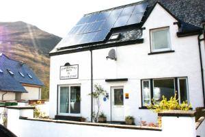 a white house with solar panels on the roof at Park View in Ballachulish