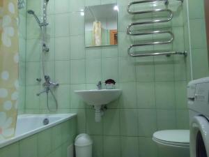 uma casa de banho com um lavatório, um chuveiro e um WC. em Amber apartamentai em Druskininkai