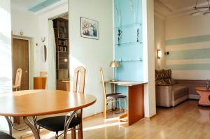 Una sala de estar con una mesa y sillas y un sofá. en Silent center Apartment, en Járkov