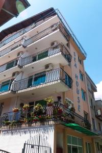 a tall building with balconies and flowers on it at Sea House Guest House in Nesebar