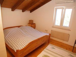 een slaapkamer met een bed in een kamer met een raam bij Apartment Skiper in Veli Lošinj