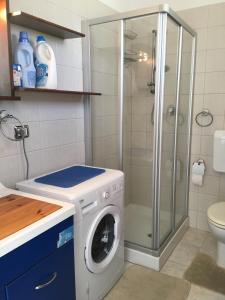 アルカモ・マリーナにあるMG Apartmentのバスルーム(シャワー付)の洗濯機が備わります。