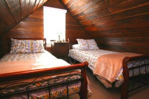 Zimmer im Dachgeschoss mit 2 Betten und einem Fenster in der Unterkunft Westbury Gingerbread Cottages in Westbury