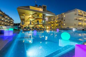 een zwembad voor een gebouw 's nachts bij Aparthotel Odissea Park in Santa Susanna