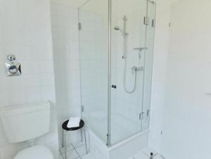 ein Bad mit einer Dusche, einem WC und einem Stuhl in der Unterkunft moderne Ferienwohnung (App.30) - Ostseeurlaub in Timmendorfer Strand