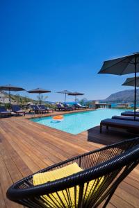 a swimming pool with chairs and umbrellas on a deck at Seametry Apartments in Souda