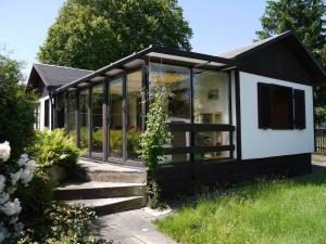 ein schwarzweißes Haus mit Glasfenstern in der Unterkunft Ferienhaus Maxen in Müglitztal