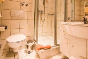 ein Bad mit einem WC, einer Dusche und einem Waschbecken in der Unterkunft Garni Hotel & Ferienwohnungen Seeschlößchen in Waldeck