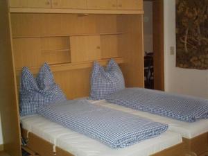 2 Betten mit blauen und weißen Kissen darauf in der Unterkunft Sport Alpin Wohnung 130 in Oberstdorf