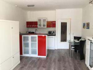 a kitchen with red and white cabinets and a table at Ferienwohnung-Kassiopeia-3 in Laboe