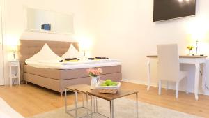 ベルリンにあるLovely-Flats "Kamminer VH"のベッド1台、テーブル(フルーツボウル付)が備わる小さな客室です。