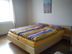 ein Bett mit einer bunten Decke auf einem Zimmer in der Unterkunft Ferienwohnung Eiche-Stadelhofer in Konstanz