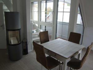 einen Tisch und Stühle im Wohnzimmer mit Kamin in der Unterkunft PIRATENNEST 2 in Zingst