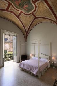 a bedroom with a bed with a painting on the ceiling at Relais Monastero Santa Teresa - Albergo Diffuso in Nardò