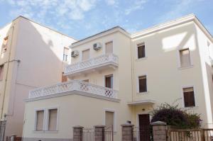 a white house with a balcony on top of it at Liberty Guest House in Alghero