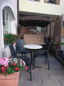 a table and chairs on a patio with flowers at Hotel Nès Crépes in Pozza di Fassa