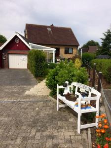 a garden with two stuffed animals sitting on a bench at Goldene-Linie-4-Taubennest in Wangerland