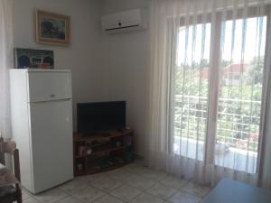 uma sala de estar com televisão e uma grande janela em Apartment Lokvice em Novalja