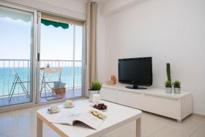 a living room with a tv and a table at Apartments Cullera Beach in Cullera